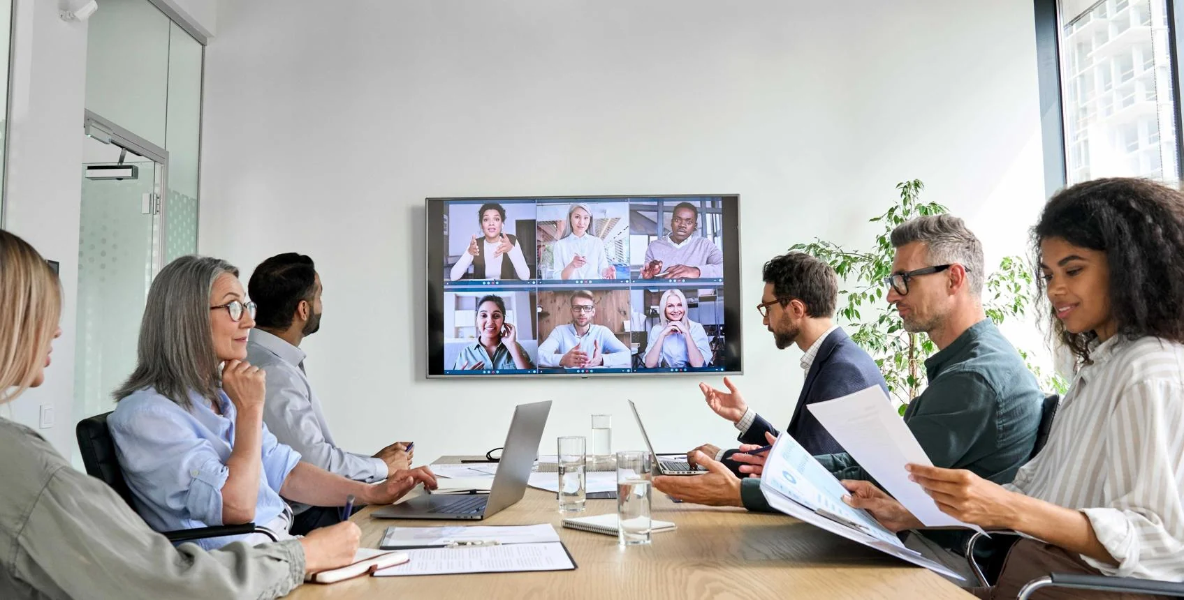 Office and remote team members collaborating in a video meeting