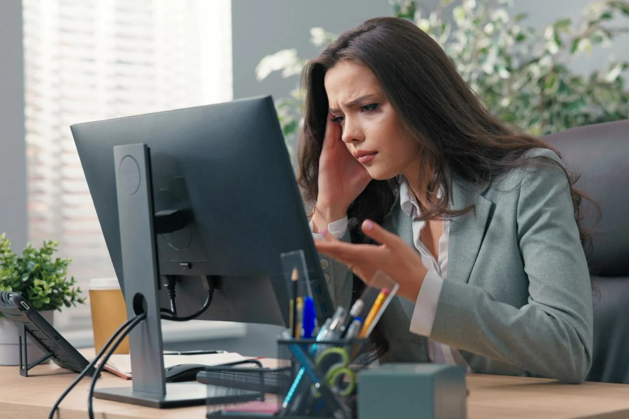 Business professional troubleshooting an issue at a desktop computer